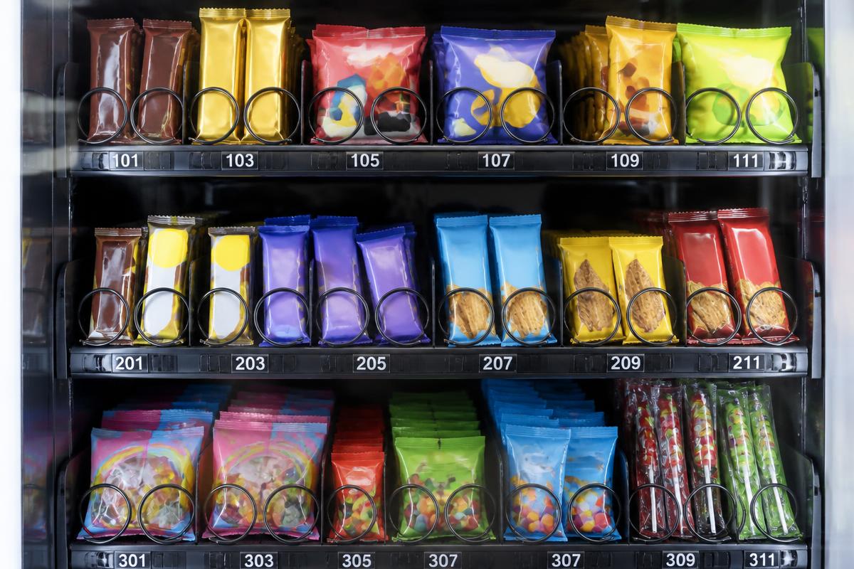 Vending machine snack trays loaded with chocolate bars, chips, biscuits and confectionery